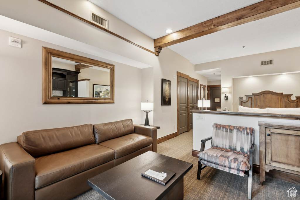 Bedroom featuring beamed ceiling and light carpet