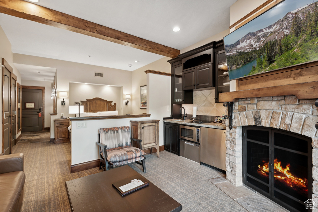 Carpeted living room featuring beam ceiling, a fireplace, sink, and a mountain view