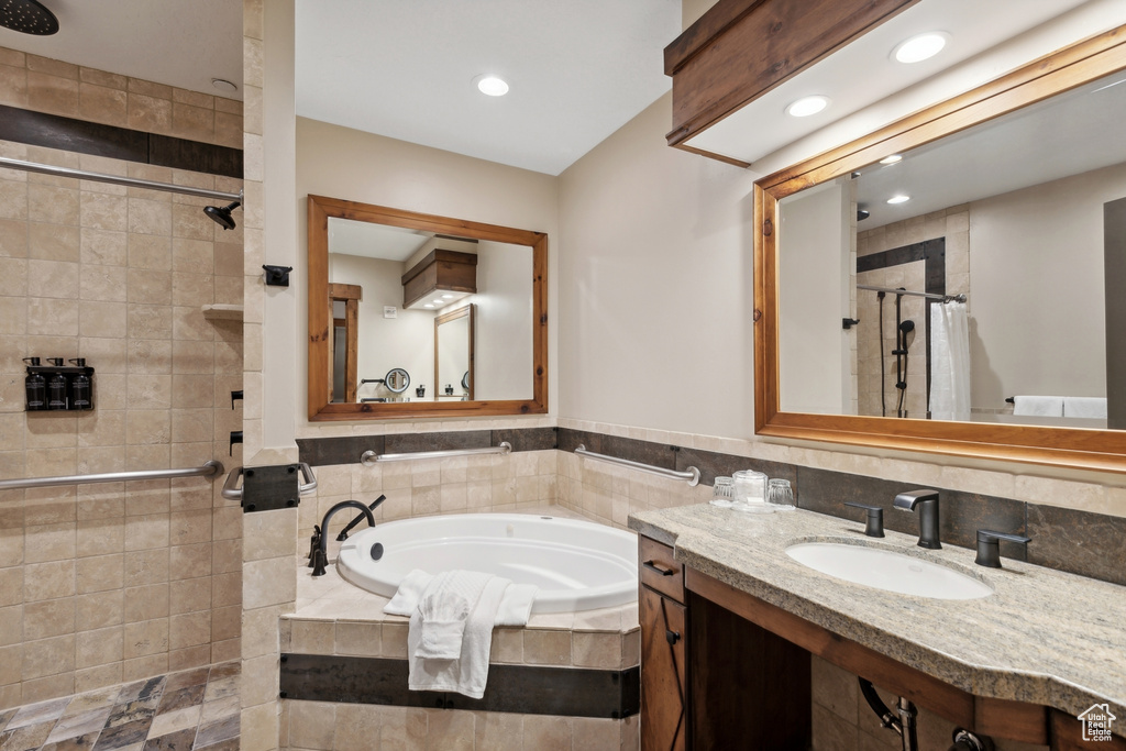 Bathroom with decorative backsplash, independent shower and bath, and vanity