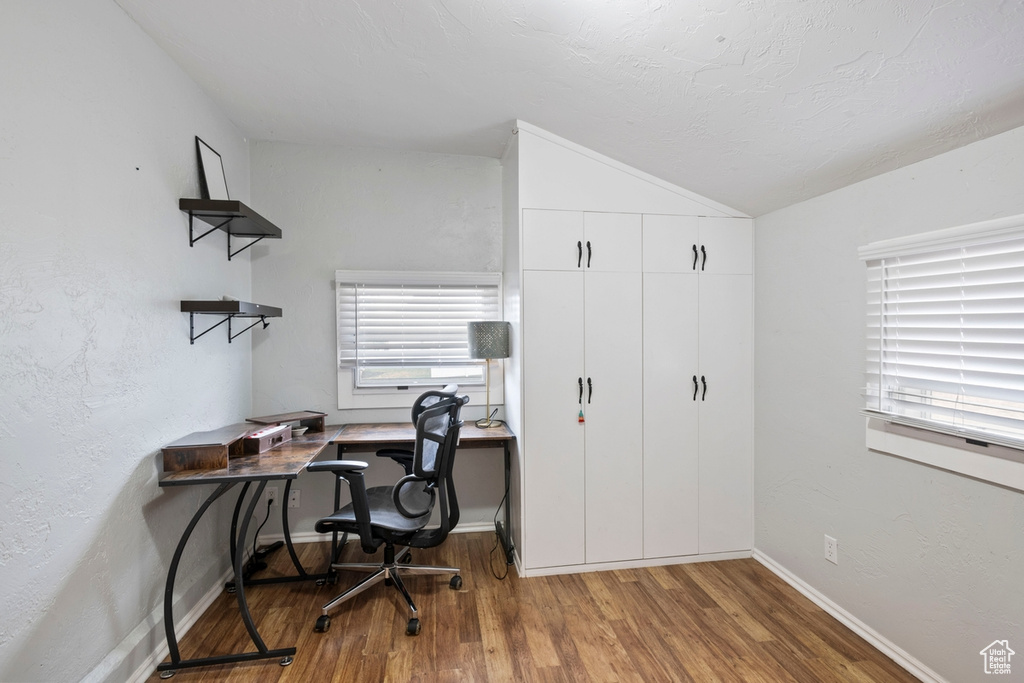 Office area featuring wood-type flooring and vaulted ceiling