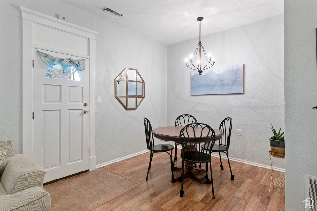 Dining space featuring light wood-type flooring and a notable chandelier