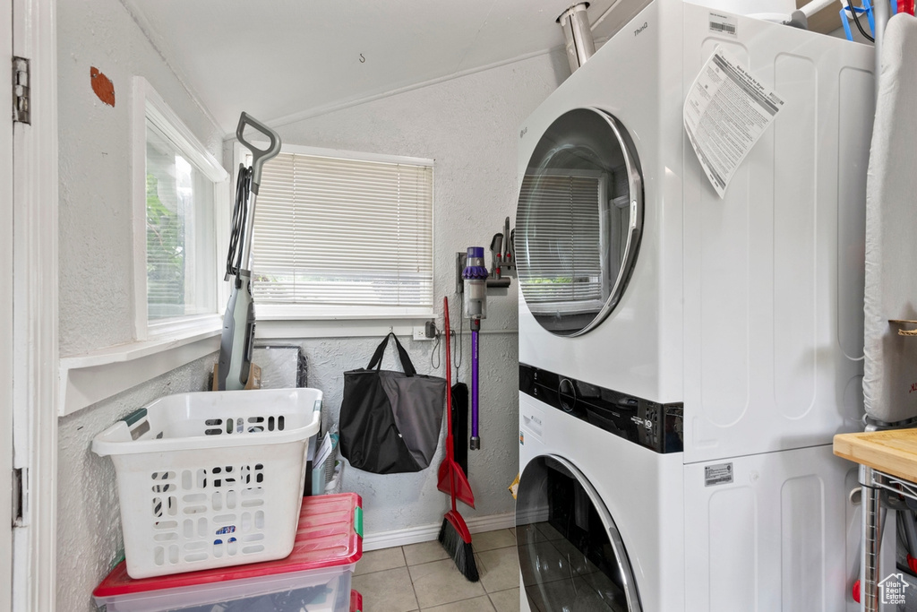 Laundry room featuring stacked washer / dryer and light tile patterned floors