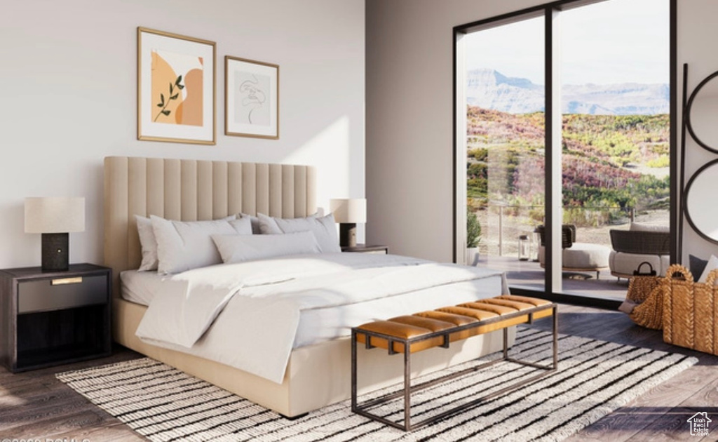 Bedroom featuring a mountain view, multiple windows, wood-type flooring, and access to exterior