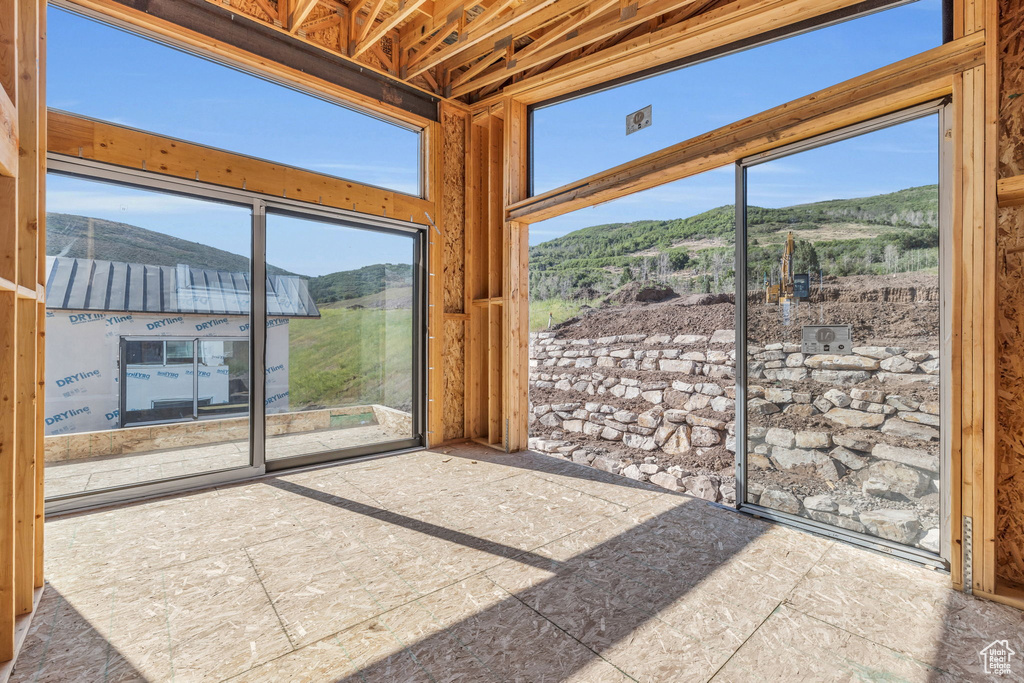 Unfurnished sunroom featuring a mountain view and plenty of natural light