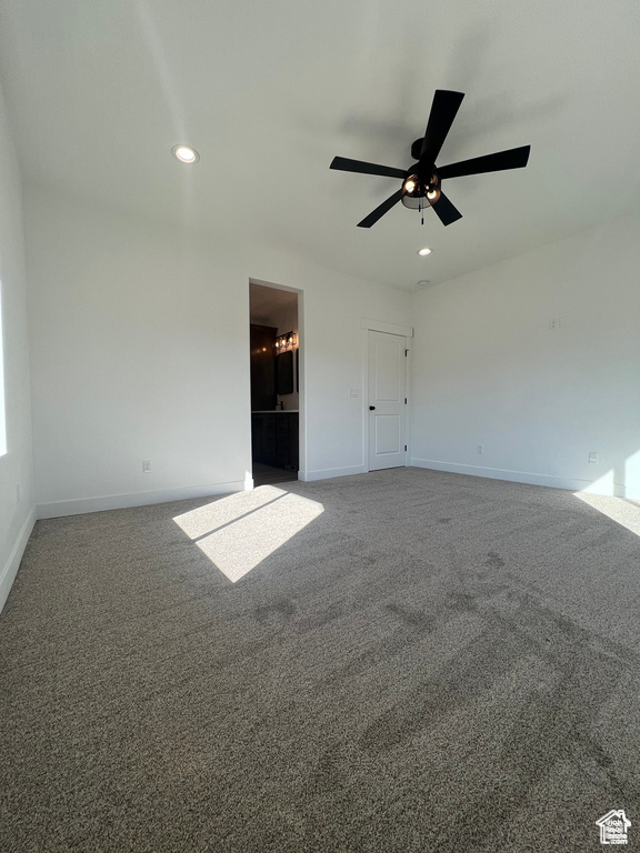 Unfurnished bedroom featuring ensuite bath, carpet floors, and ceiling fan