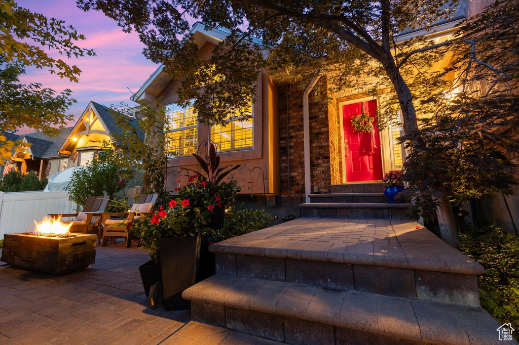 Exterior entry at dusk with a patio