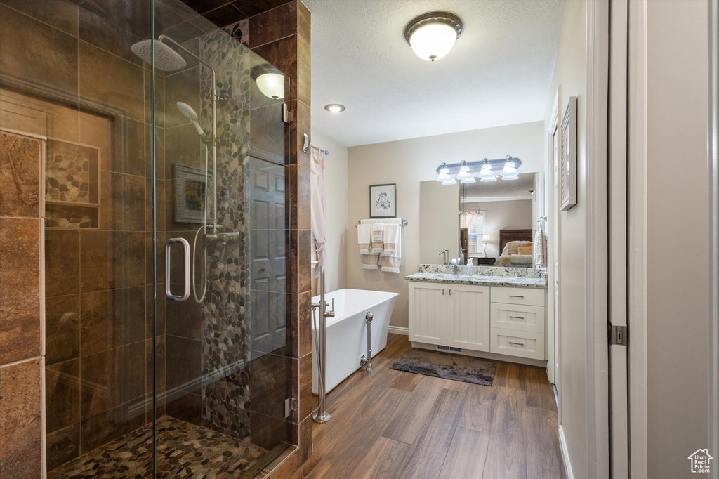 Bathroom featuring independent shower and bath, vanity, and hardwood / wood-style floors