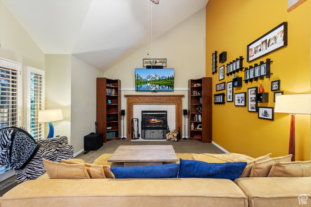 Carpeted living room with a tile fireplace and high vaulted ceiling