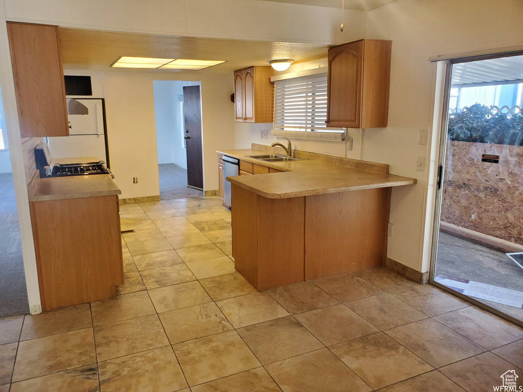 Kitchen featuring light tile patterned floors, dishwasher, sink, and plenty of natural light