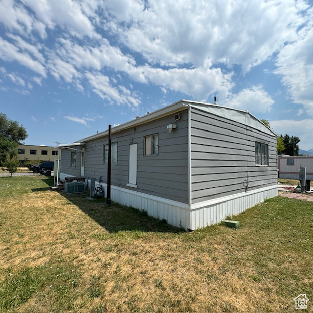 View of property exterior featuring a lawn