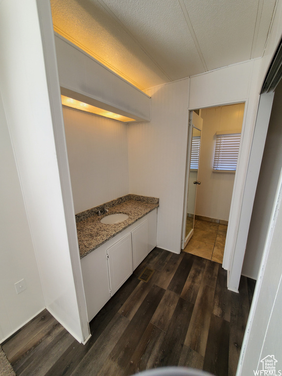 Bathroom featuring vanity, a textured ceiling, and hardwood / wood-style flooring