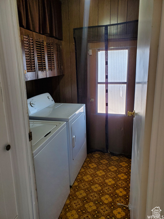 Laundry room featuring tile patterned floors, cabinets, and washer and dryer