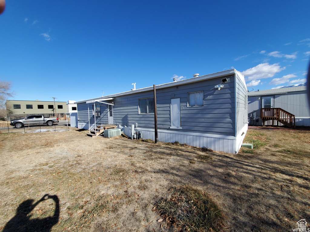 Rear view of house with cooling unit and a deck