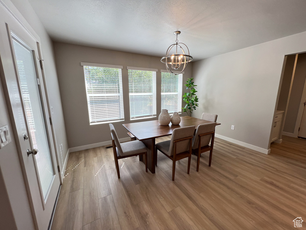 Dining room featuring light wood-type flooring and an inviting chandelier