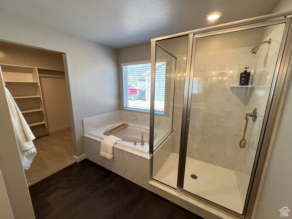 Bathroom featuring independent shower and bath, wood-type flooring, and a textured ceiling