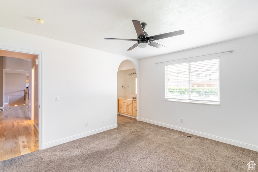 Carpeted empty room featuring ceiling fan