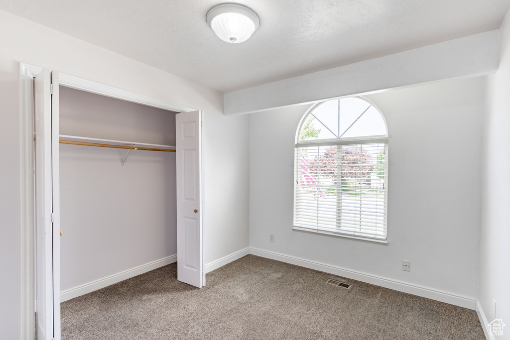 Unfurnished bedroom with carpet flooring and a closet