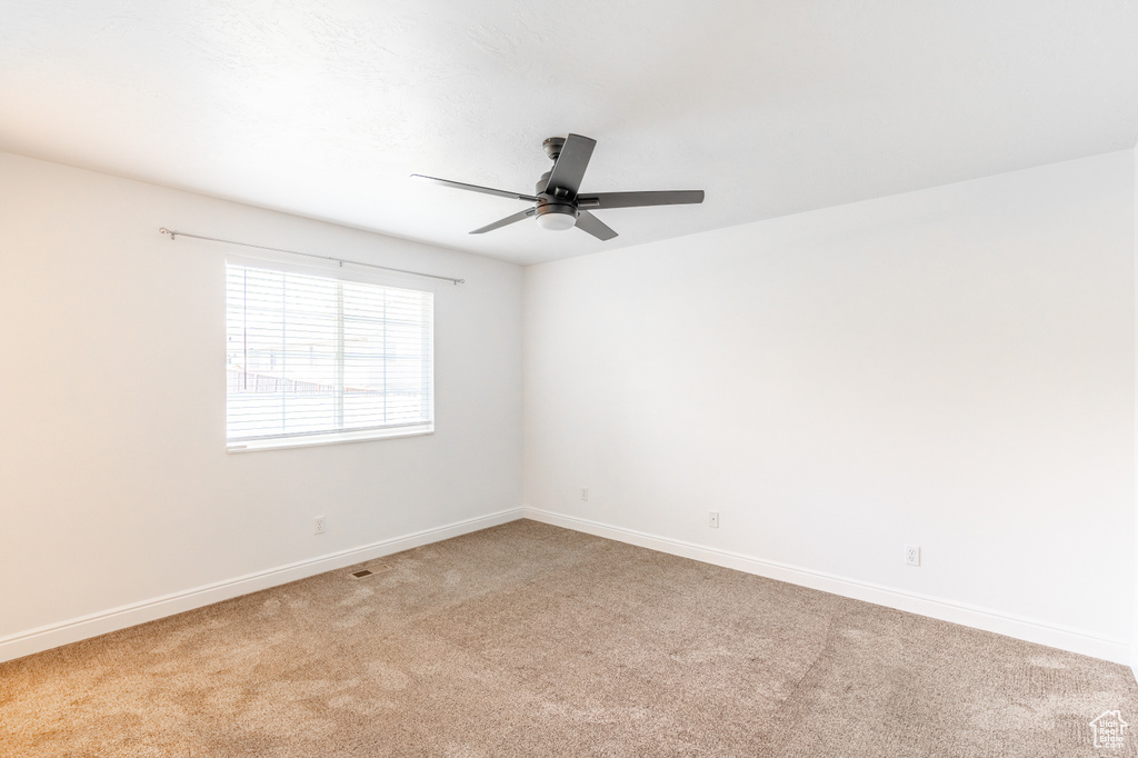 Carpeted spare room with ceiling fan