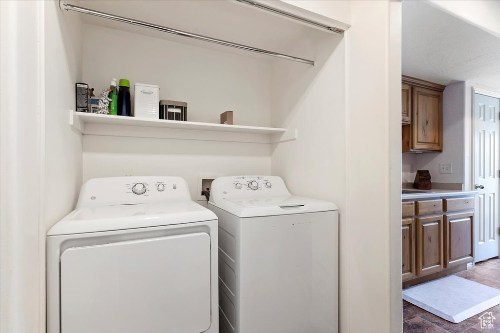 Laundry area with dark tile patterned flooring and washer and dryer