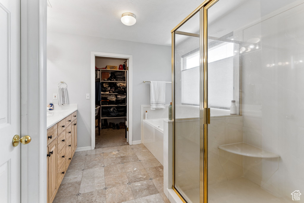 Bathroom featuring vanity, plus walk in shower, and tile patterned flooring