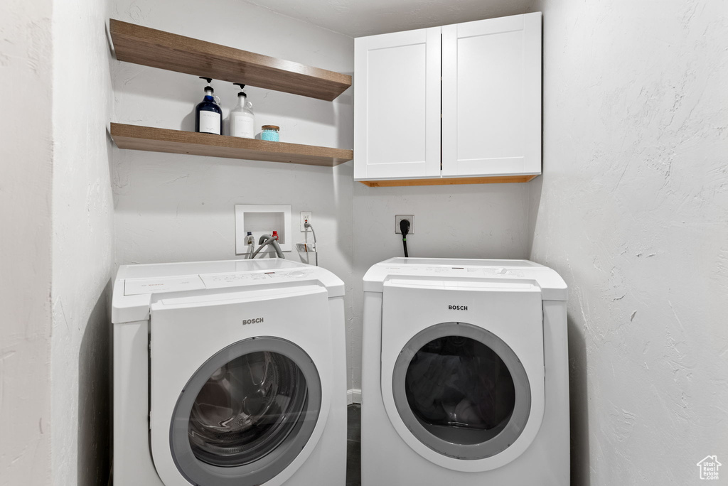 Clothes washing area with cabinets and washer and dryer