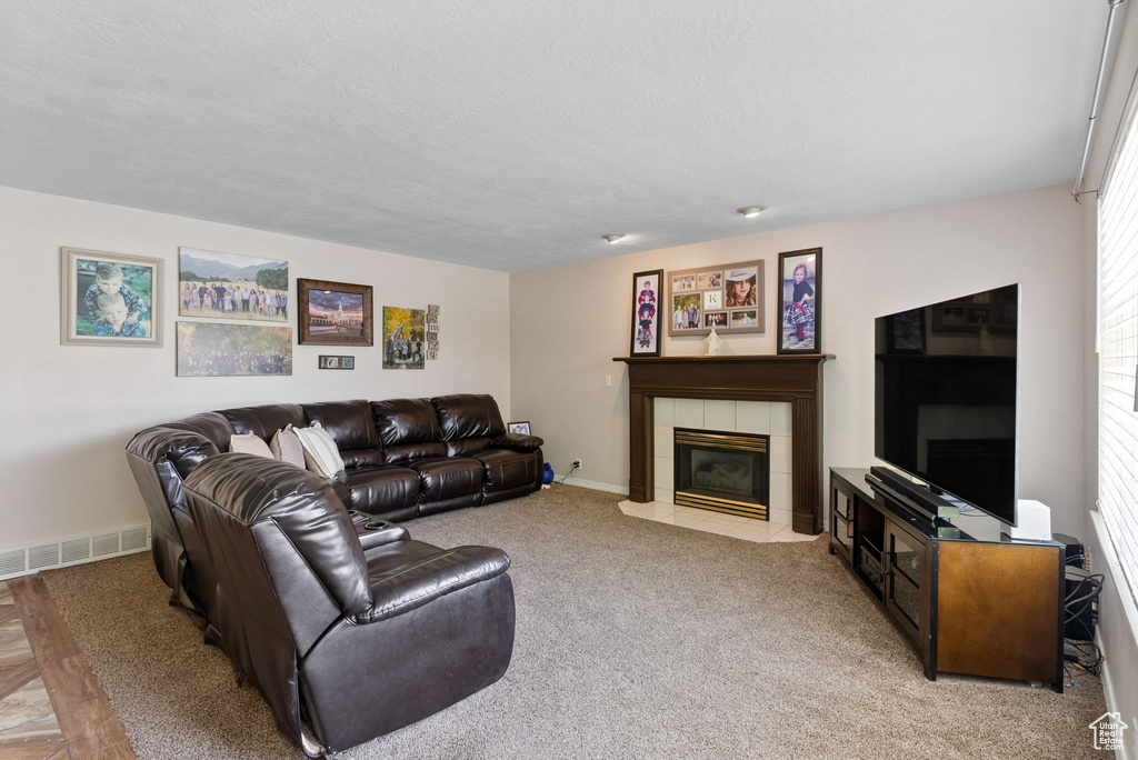 Carpeted living room with a tile fireplace