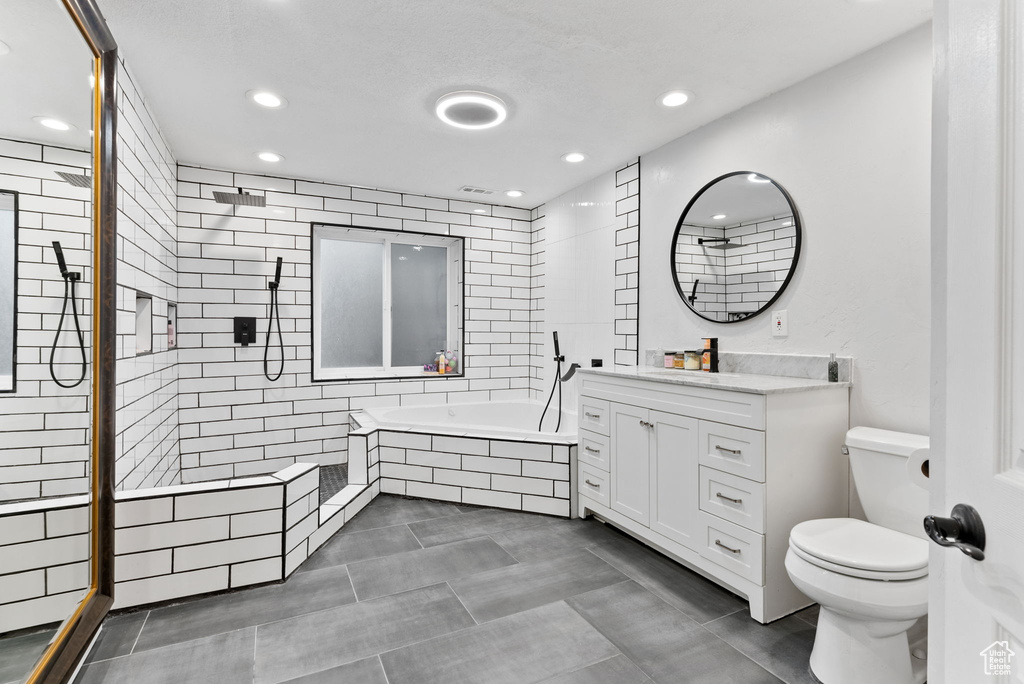 Full bathroom with vanity, plus walk in shower, tile patterned flooring, and toilet