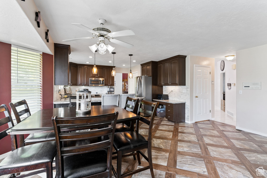 Dining space featuring ceiling fan and light tile patterned floors