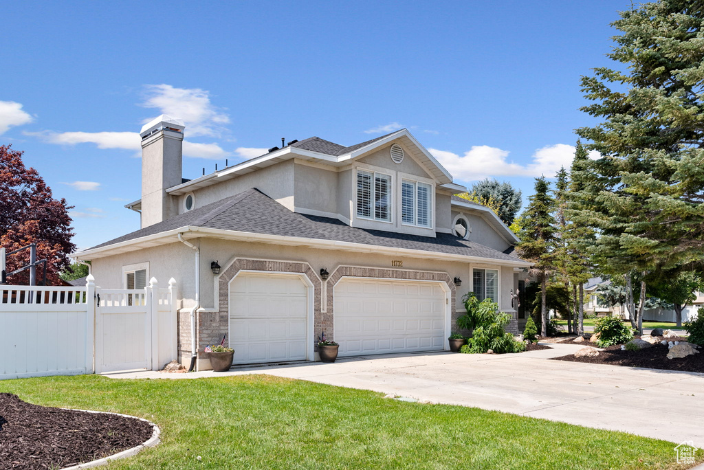 Front of property with a garage and a front yard