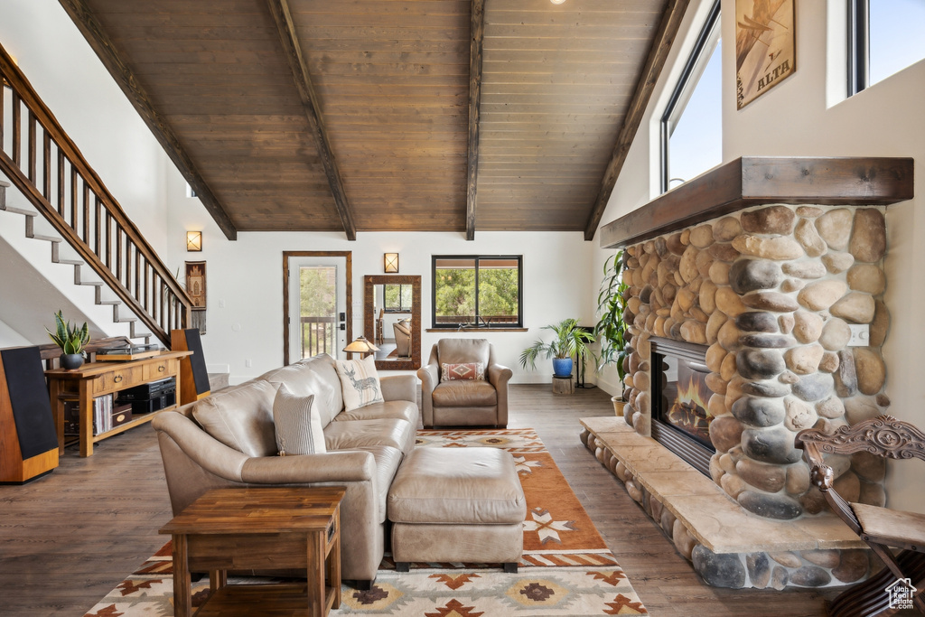 Living room with beam ceiling, hardwood / wood-style floors, wooden ceiling, a fireplace, and high vaulted ceiling