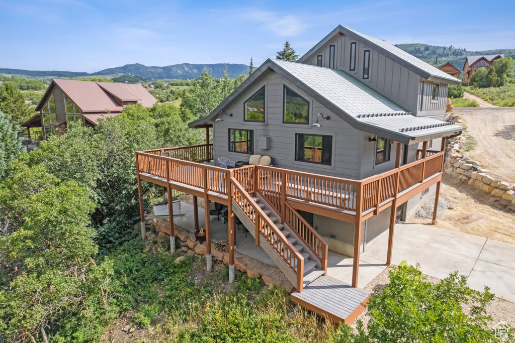 Back of house with a deck with mountain view