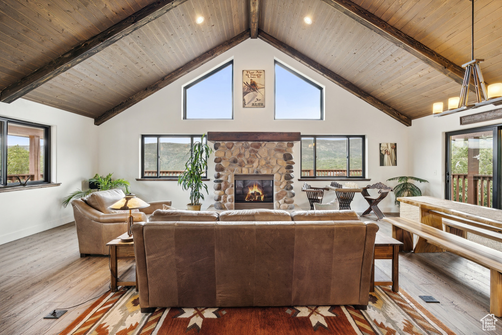 Living room with beamed ceiling, a fireplace, wooden ceiling, and hardwood / wood-style floors