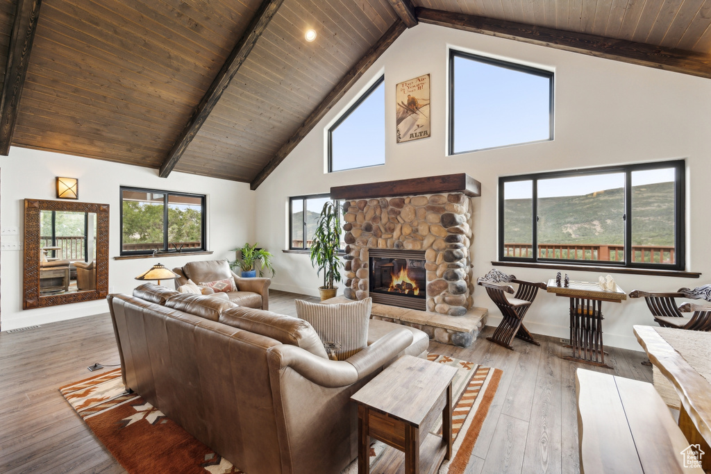 Living room with wood ceiling, high vaulted ceiling, and a fireplace