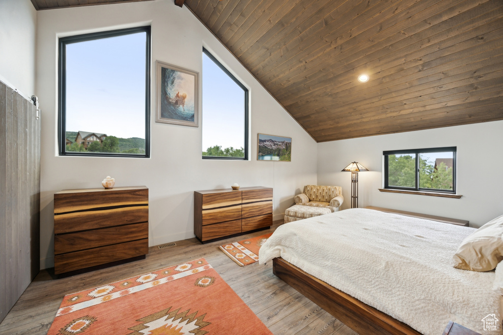 Bedroom featuring lofted ceiling, light hardwood / wood-style floors, and wood ceiling