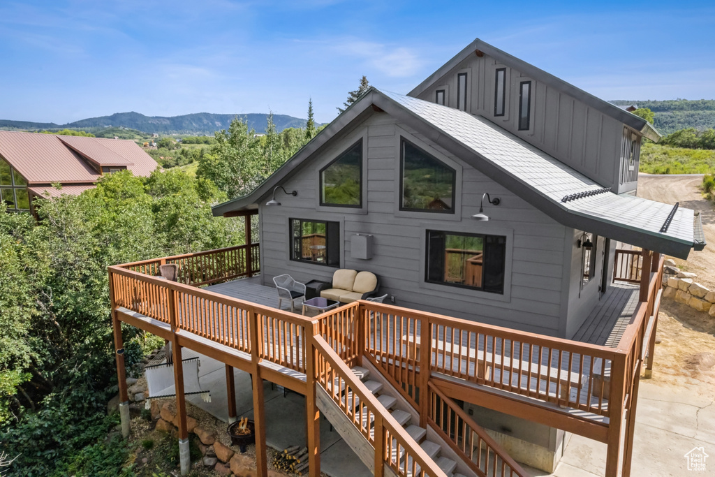 Rear view of house featuring a deck with mountain view