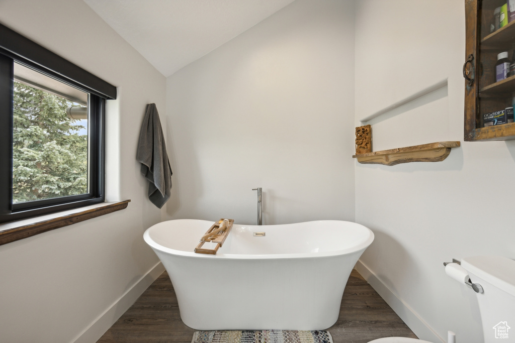 Bathroom featuring lofted ceiling, wood-type flooring, and toilet