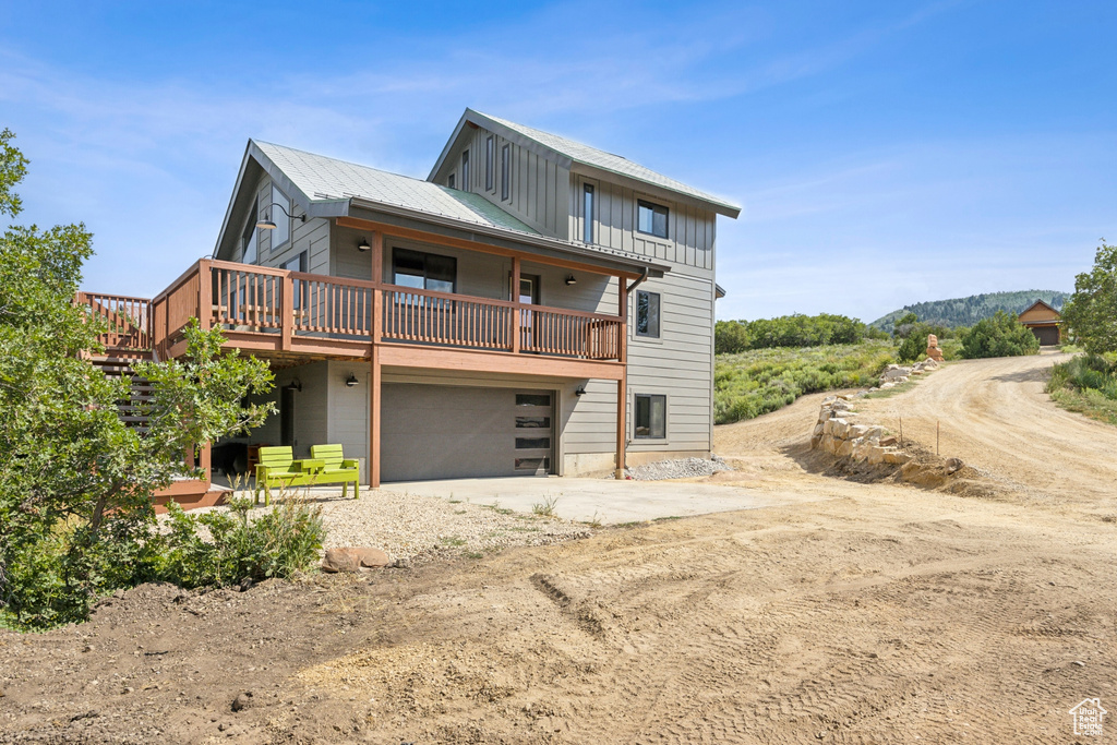 View of front of home with a garage and a wooden deck