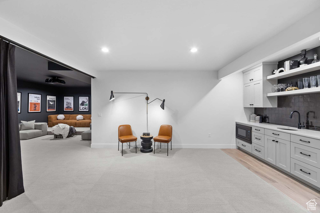 Sitting room with sink and light hardwood / wood-style flooring