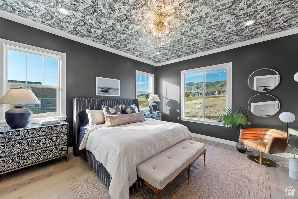 Bedroom featuring ornamental molding and hardwood / wood-style flooring