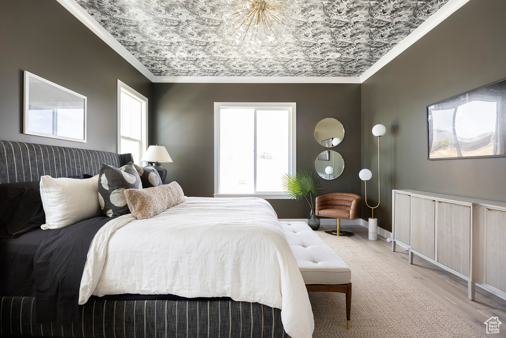 Bedroom with ornamental molding and light hardwood / wood-style floors