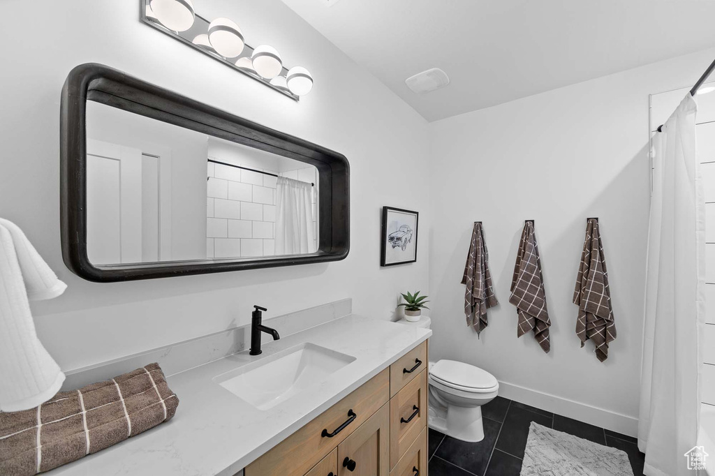 Bathroom with tile flooring, vanity, and toilet