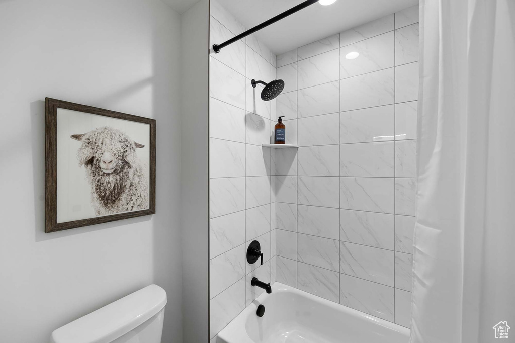 Bathroom featuring shower / tub combo with curtain and toilet