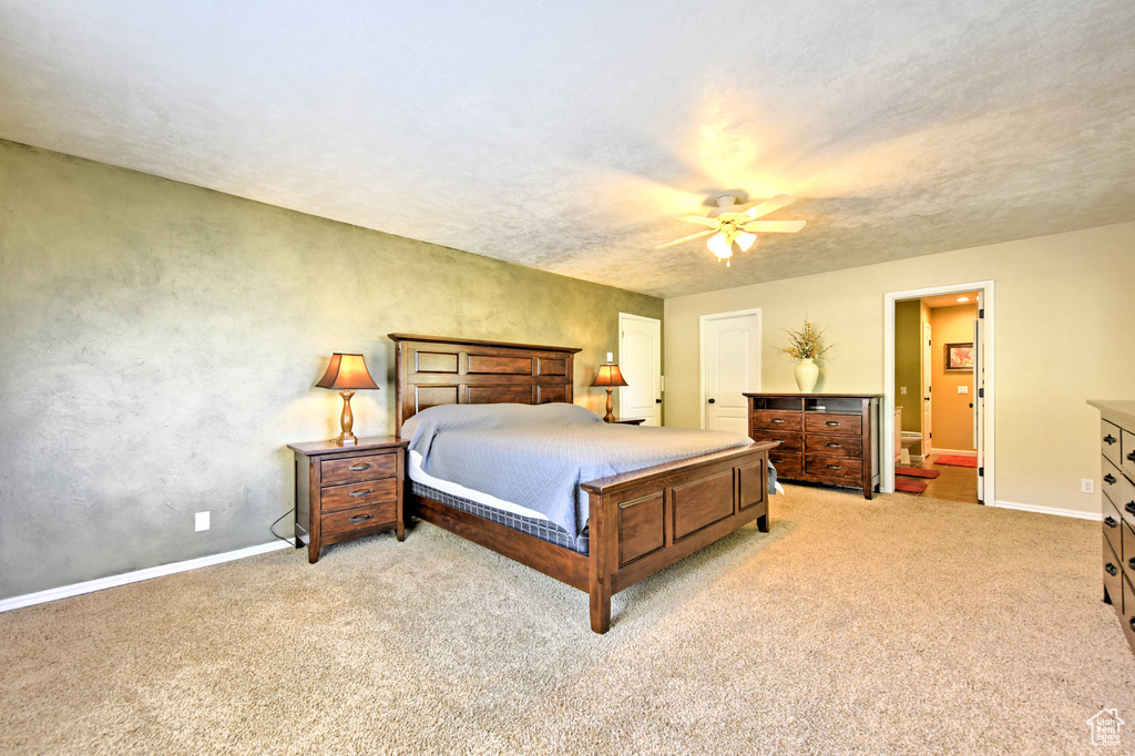 Carpeted bedroom featuring ceiling fan