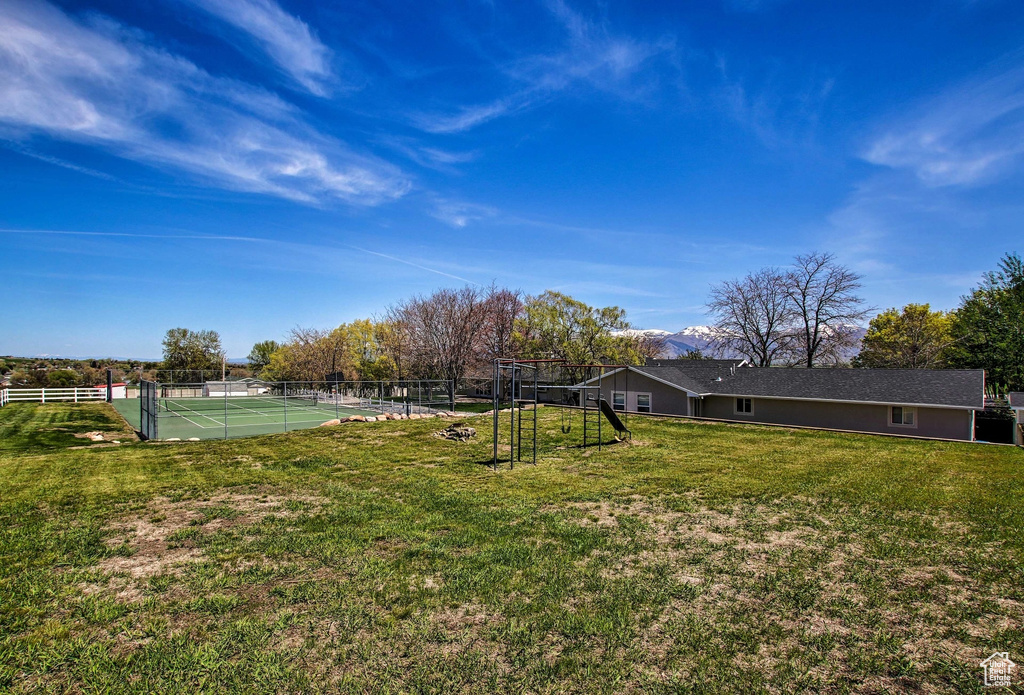 View of yard featuring tennis court and a rural view