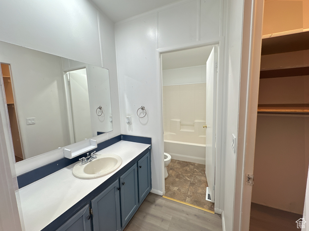 Full bathroom featuring shower / bathing tub combination, wood-type flooring, vanity, and toilet