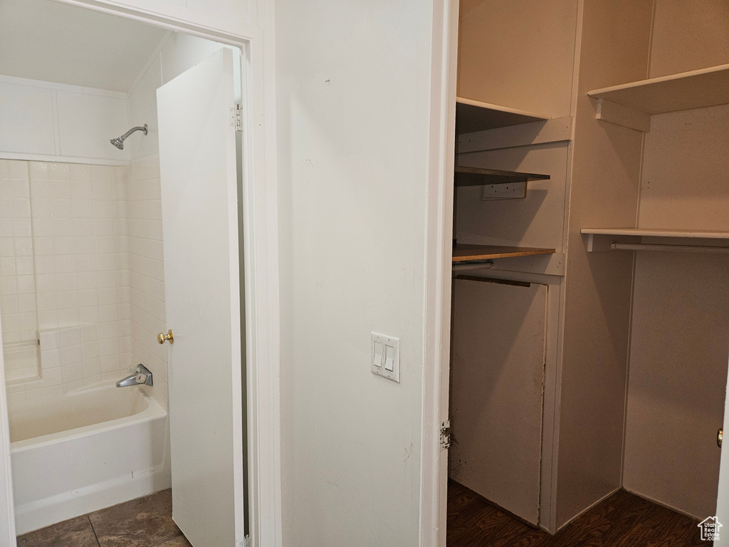 Bathroom with shower / bathing tub combination and hardwood / wood-style floors