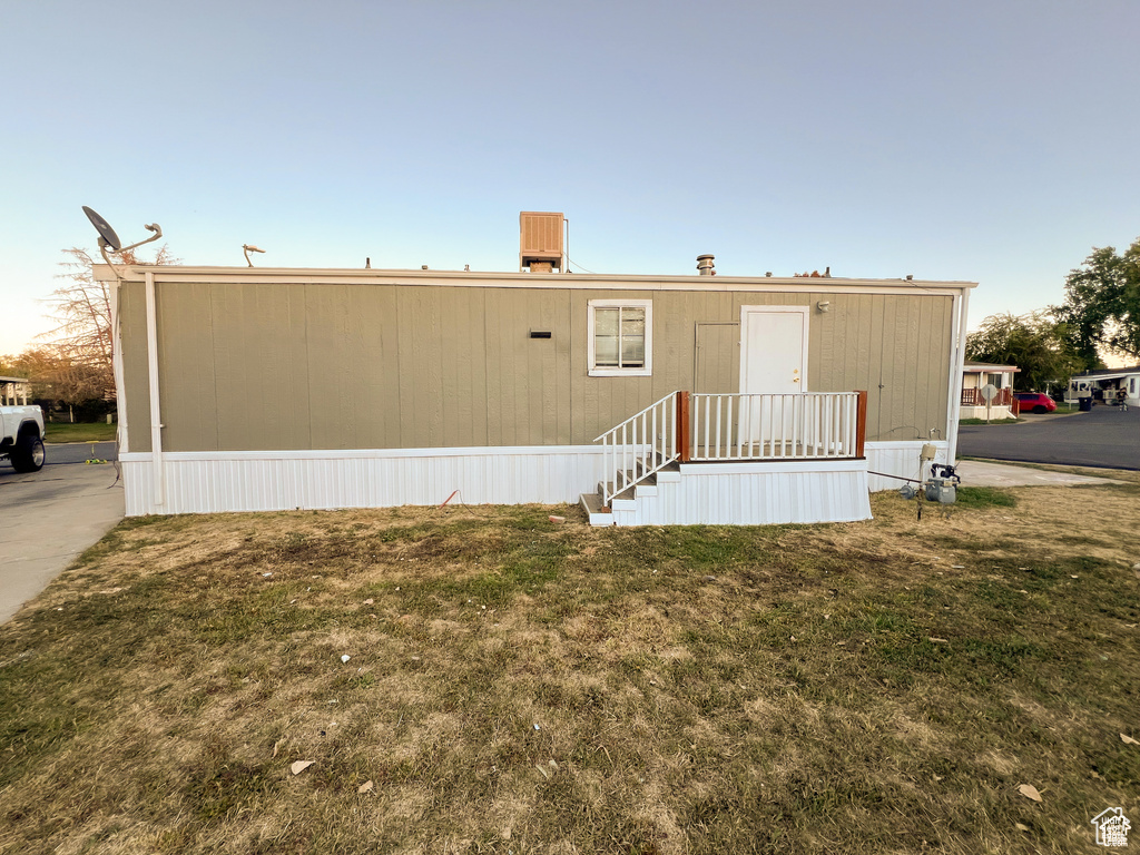 Rear view of property with a yard