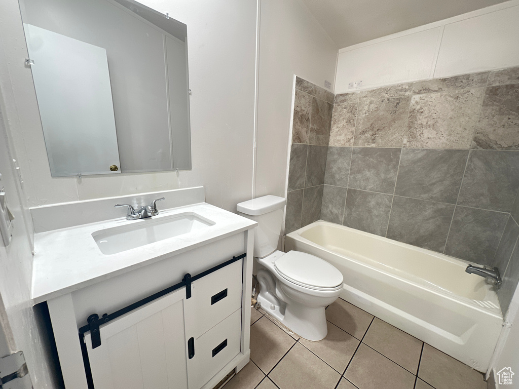 Full bathroom featuring tile patterned flooring, vanity, toilet, and tiled shower / bath combo