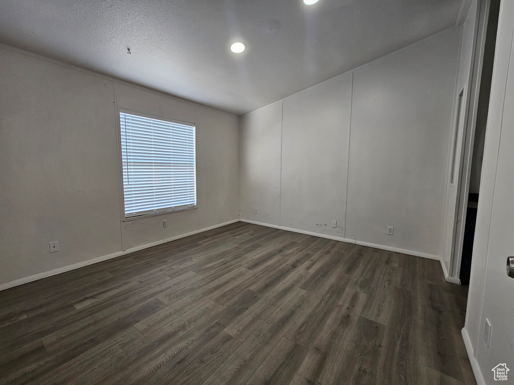 Spare room featuring dark hardwood / wood-style floors and a textured ceiling