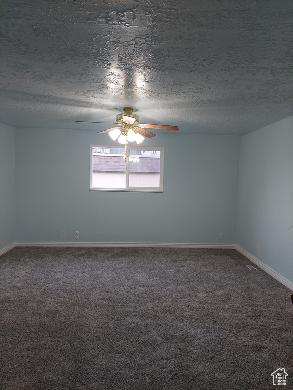 Carpeted empty room with a textured ceiling and ceiling fan